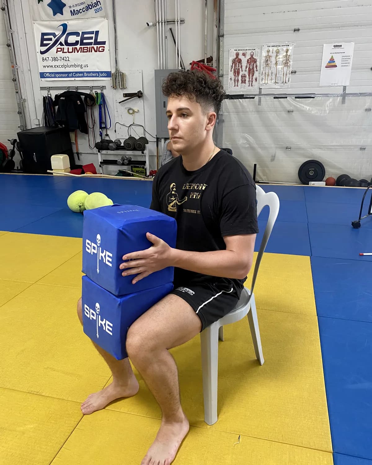 An athlete holding a SPIKE block on a training floor