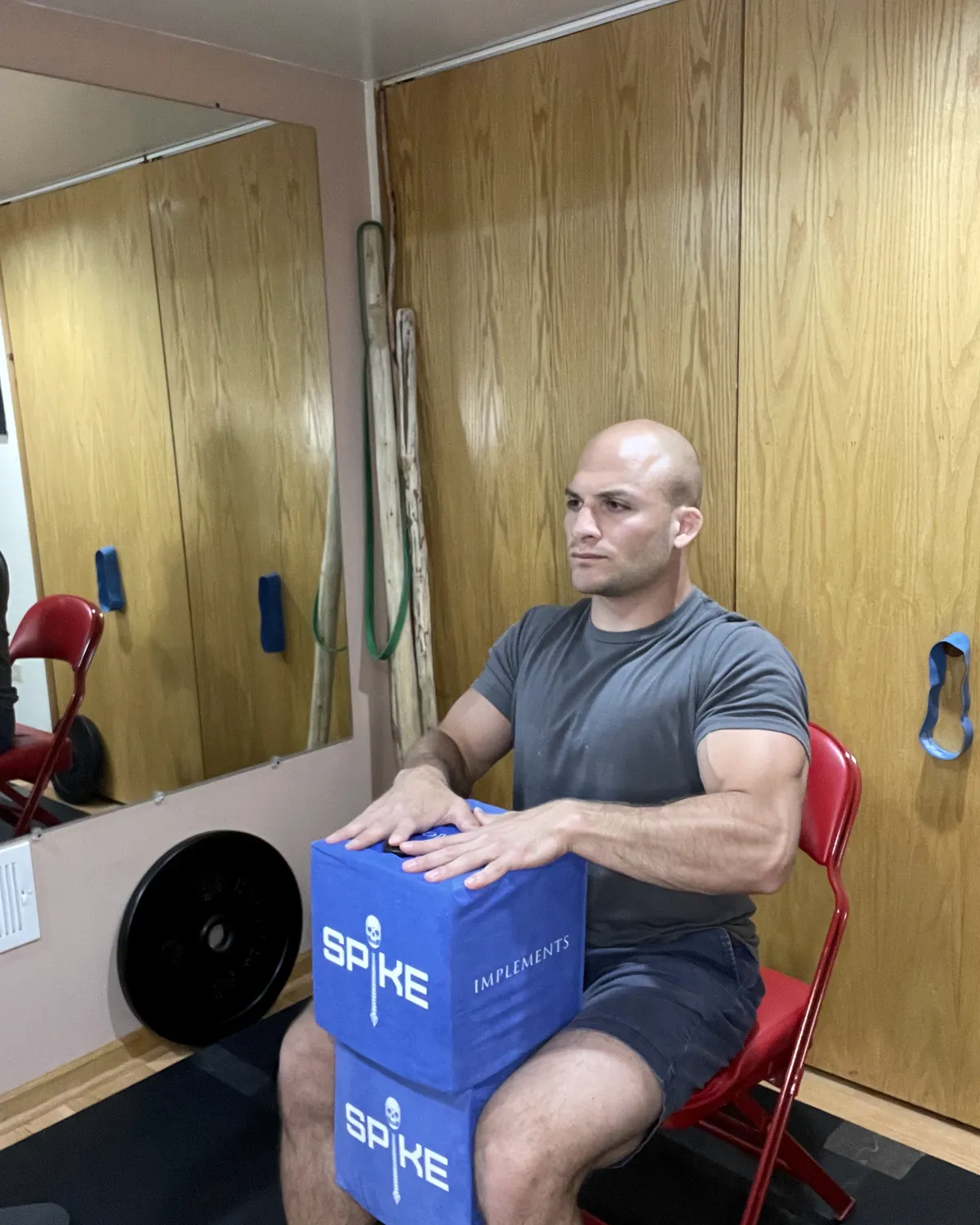 A man pressing a SPIKE block, seated in a weight room